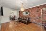 Living room with brick accent wall with view into dining room.