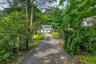Gated driveway entrance featuring stone pillars with integrated lighting