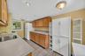 Recessed ceiling lighting, wood-finish cabinetry, stainless steel sink, and durable tile flooring