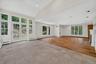 Expansive room featuring wood-finish flooring, a white mantel fireplace, and recessed lighting