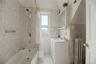 Bright, tiled full bathroom with tub and shower.