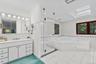 The primary bath continues with a glass-enclosed walk-in shower and a cozy fireplace, creating a warm, spa-like retreat.