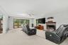 The living room is anchored by a welcoming fireplace and framed by dramatic floor-to-ceiling custom mahogany tilt-and-turn windows, where oversized gl