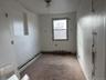 Spare room featuring healthy amount of natural light, carpet, and a baseboard heating unit