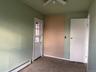 Unfurnished bedroom with a baseboard heating unit, ceiling fan, and concrete floors