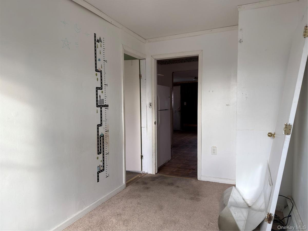 Hall featuring carpet floors and baseboards