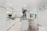 A generous center island, granite countertops, abundant white cabinetry, and a spacious pantry provide exceptional function, while premium appliances—