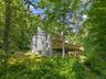Nestled on nearly three acres of lush greenery and beautiful plantings, the property offers a picturesque natural setting enhanced by tranquil riversi