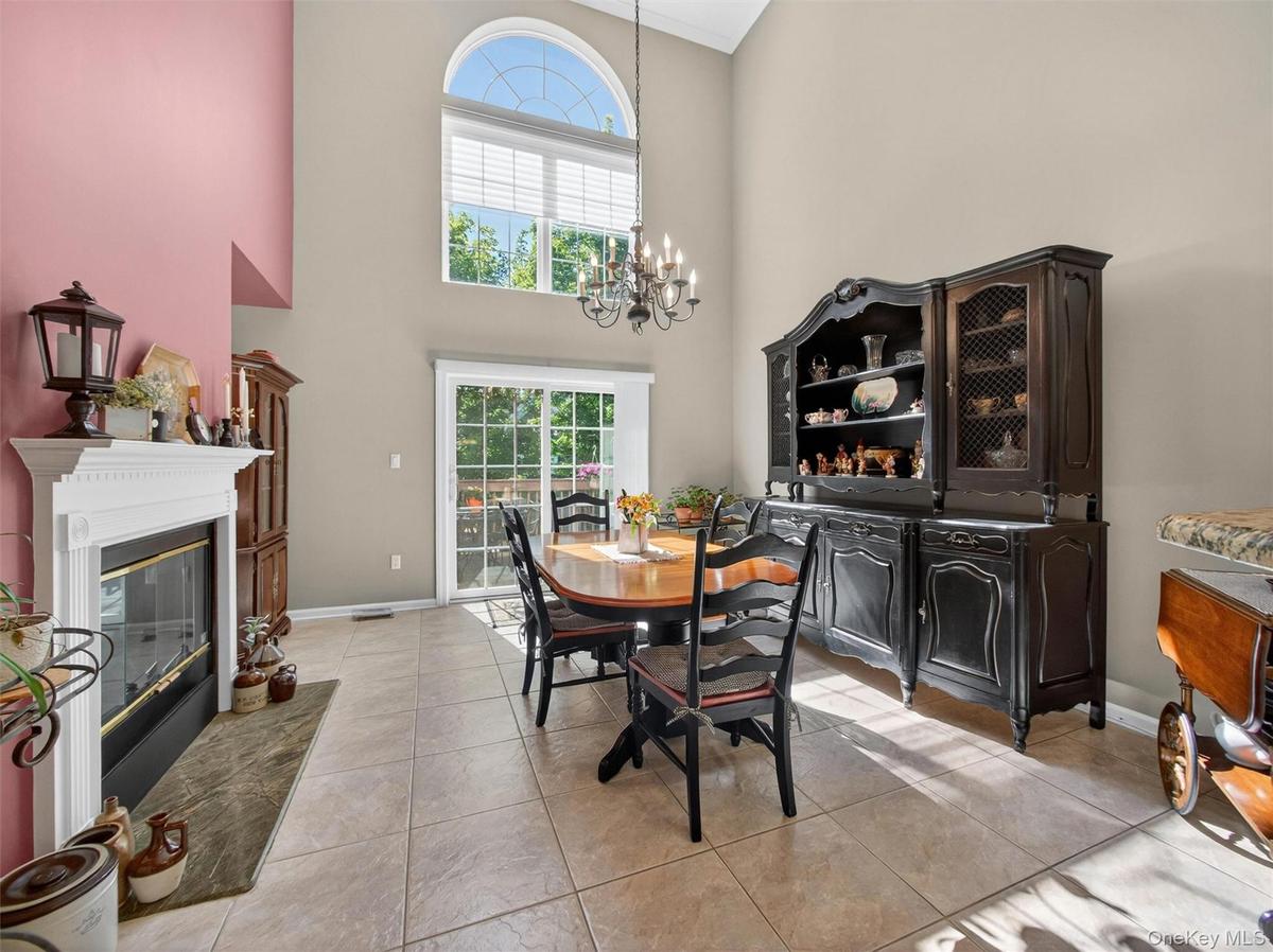Stunning open-plan formal dining room with approx 20'+ ceiling, arched window, slider to the private deck.