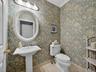 Elegant first floor powder room with wallcovering.
