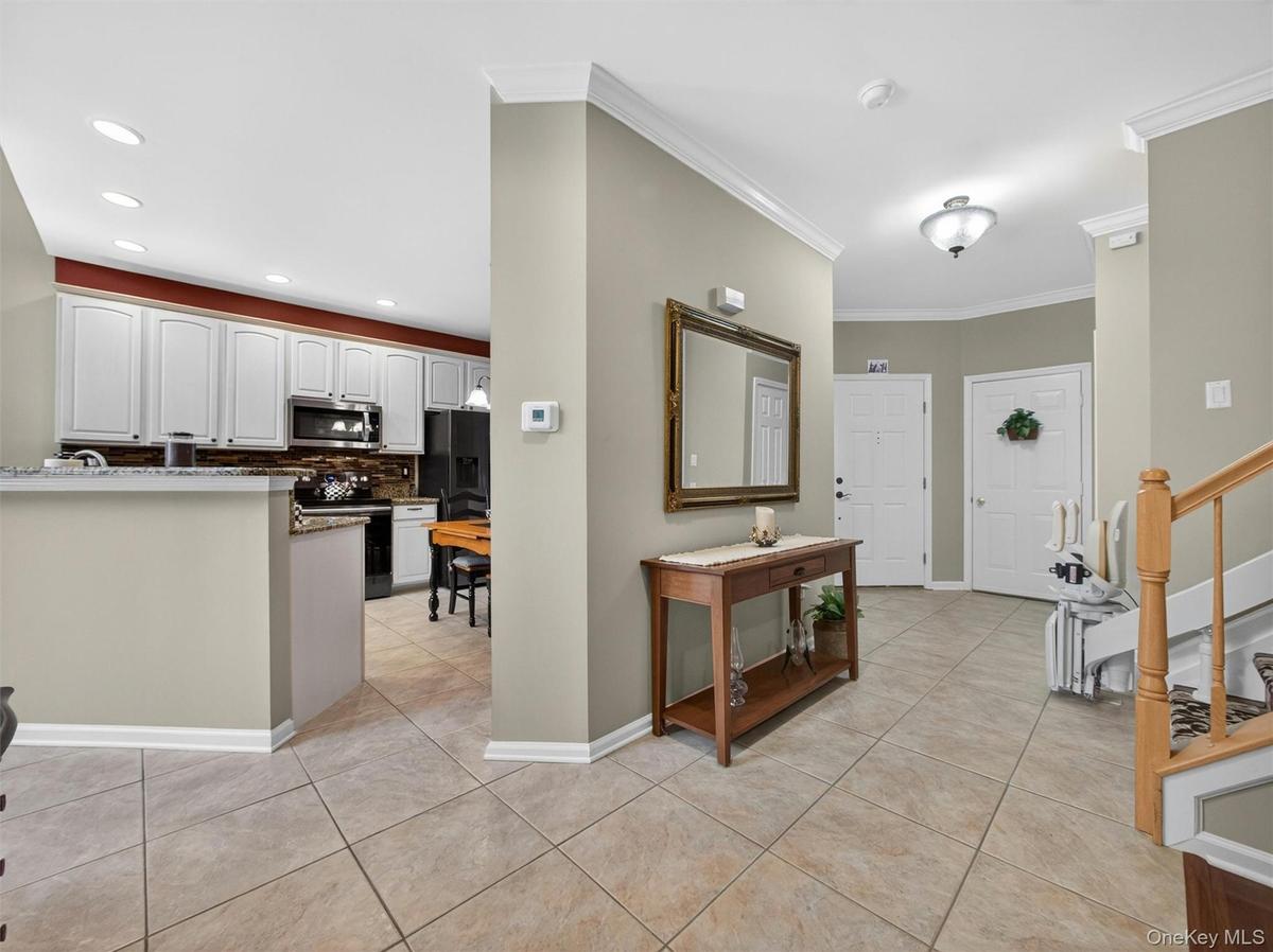 View to the entryway foyer and garage access.  Open-plan kitchen to the left.
