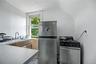 White walls with a window, stainless steel refrigerator, and stainless steel range