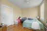 Sloped ceiling room featuring wood-finish flooring, a double window, and a flush-mount light fixture