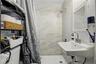 Bathroom featuring a wall-mounted sink, medicine cabinet with mirror, and shower with tiled walls