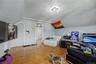 Sloped ceiling room featuring wood-finish flooring, a double window, and a flush-mount light fixture