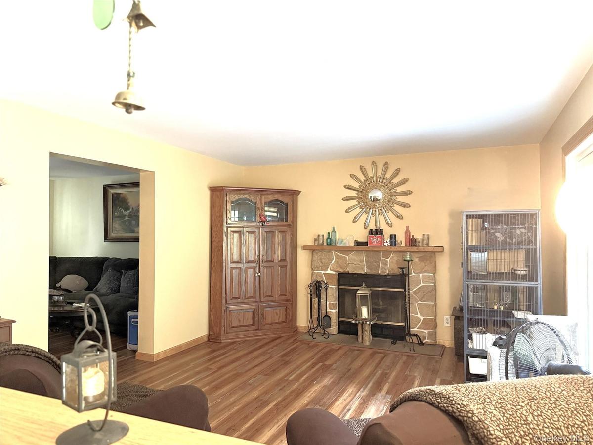 As seen from kitchen. Wood-burning fireplace, sliding door to large deck, open to living room.