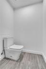 Private water closet with wood-look tile flooring