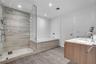 Bathroom with frameless glass shower and stone-look tile