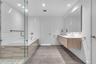 Primary bath with dual vanities, soaking tub, and walk-in shower