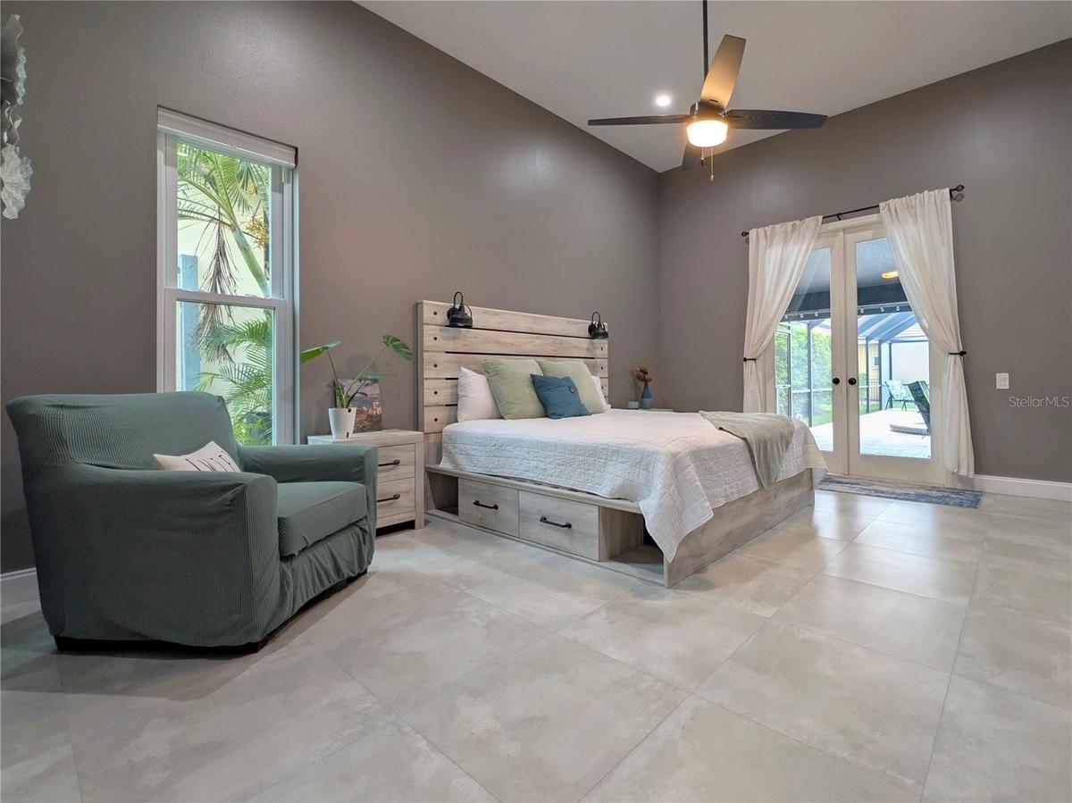 Primary Bedroom w/ french doors leading out to pool.