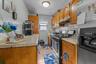 Kitchen featuring wood cabinetry, light-toned countertops, a tile backsplash, and stainless steel appliances.