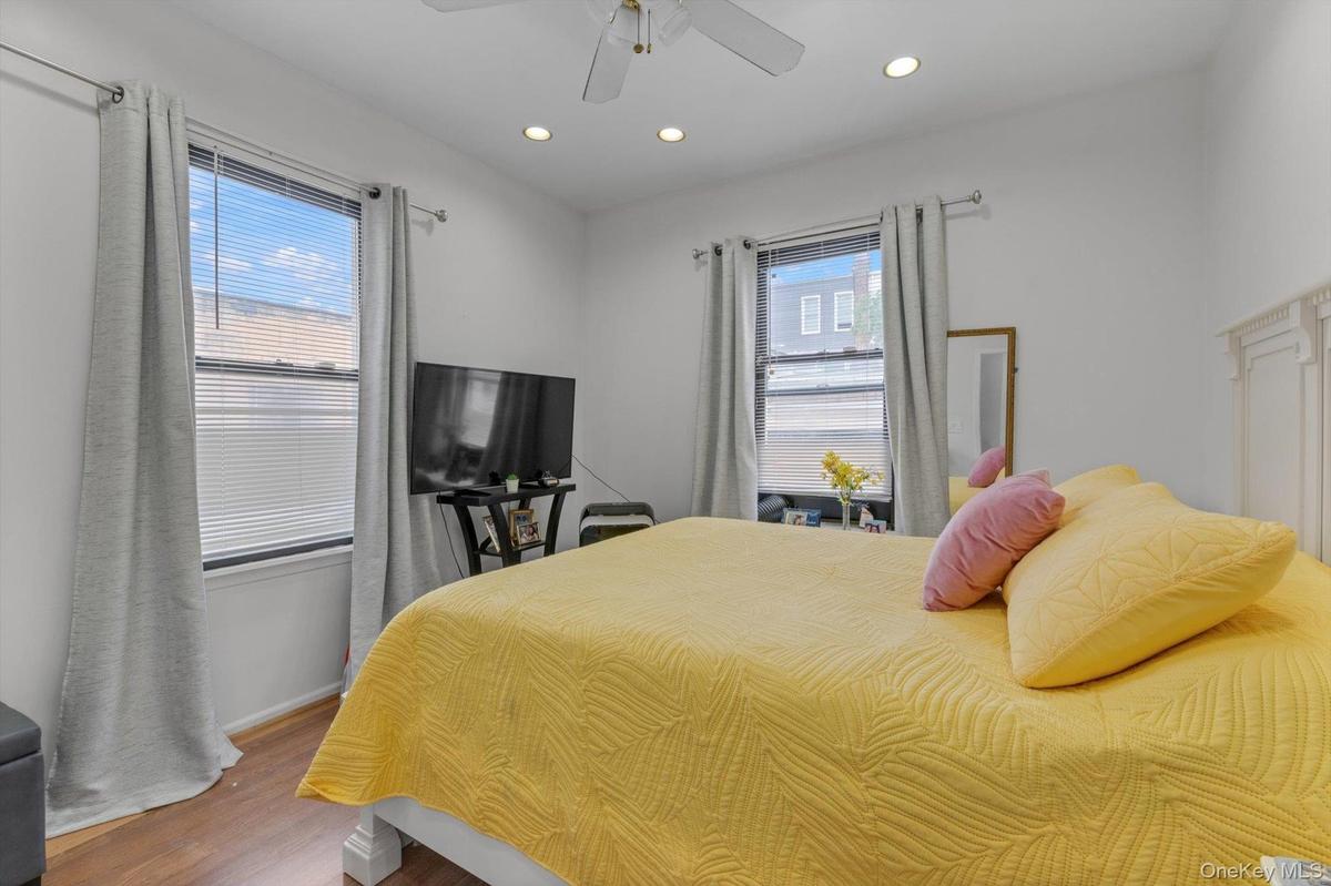 Recessed lighting, ceiling fan, wood-finish flooring, and two windows.