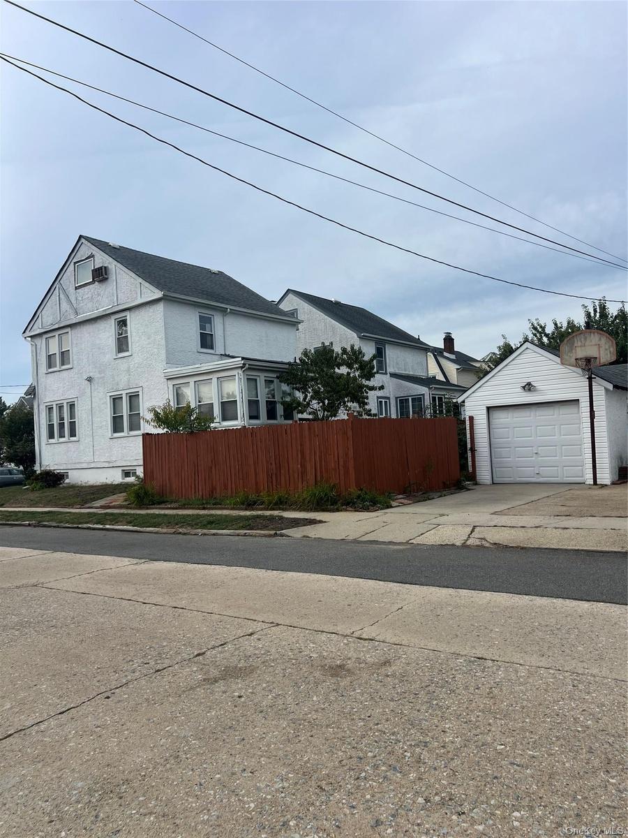 View of home's exterior with a detached garage, an outdoor structure, and driveway