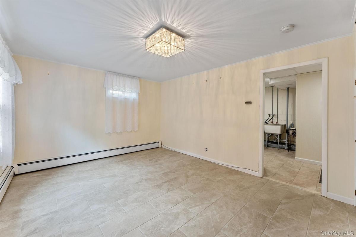 Ground level recreation room looking toward the laundry room and access to the one-car garage.
