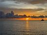 The sky turns to molten gold over the calm waters.