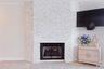 Natural stone facade frames the primary bedroom's fireplace and ties the spaces together.
