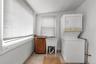 Laundry area with a utility sink, wood-finish cabinetry, and tiled flooring
