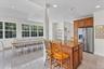 Kitchen with wood cabinetry, stainless steel refrigerator, and a granite-topped island