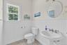 White beadboard paneling, pedestal sink, chrome faucet, and tiled flooring