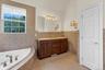 Corner soaking tub with deck-mounted fixtures