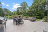 View of patio / terrace featuring an outdoor pool, outdoor dining space, view of wooded area, area for grilling, and an outdoor living space