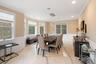 Dining space featuring light marble finish floors, a wainscoted wall, a decorative wall, crown molding, and a chandelier
