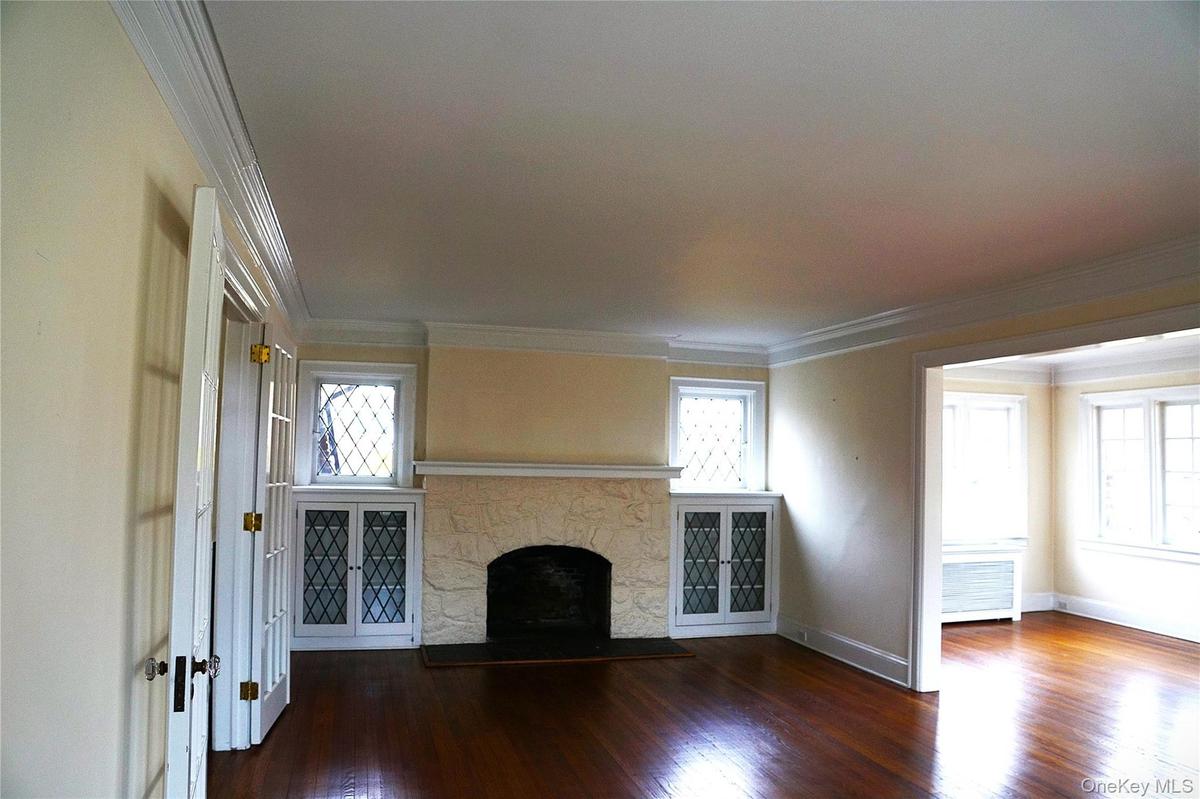 Living room featuring wooden floors a fireplace and to the right of the photo it flows right into the library slash den slash office