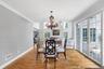 Hardwood flooring throughout, elegant crown molding, double French doors with transom windows, and a chandelier light fixture and access to outdoor pa