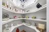 Very large built-in pantry closet with lots of  shelving with white finishes