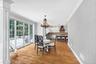 Hardwood flooring, crown molding, wall paneling, French doors, and a decorative chandelier and access to outdoor patio