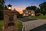 Belgium block curbing ,elegant custom stone and lighted mail box, custom pavers with evening view of  two-story residence exterior with multiple illum