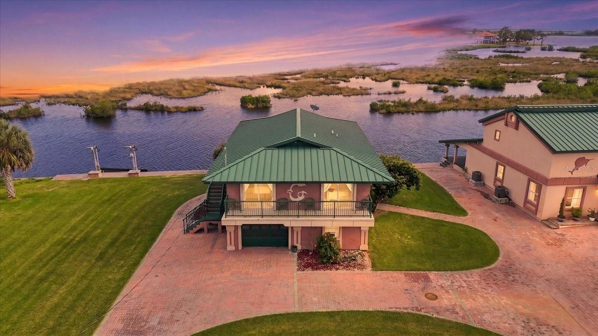 Twilight aerial showcasing the waterfront residence and natural coastal setting.