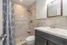 Modern bathroom featuring a spacious walk-in shower with tile surround and glass enclosure, a sleek vanity with white quartz countertop and dual-sink 