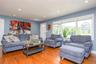 Recessed lighting illuminates the open living area featuring wood-finish flooring, a white paneled door, and a multi-pane window
