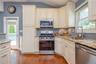 Elegant kitchen featuring cream-colored cabinetry with crown molding, granite countertops, stainless steel appliances including a gas range and built-