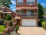 Brick exterior with a second-story balcony, covered entry, and attached garage