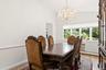 Hardwood flooring, crown molding, chair rail, and an ornate crystal chandelier illuminate the space