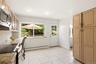 Kitchen featuring light wood-finish cabinetry, tile flooring, and granite-look countertops