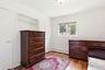 Hardwood flooring, built-in shelving, white trim, and a double-hung window
