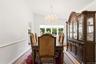 Vaulted ceiling with a crystal chandelier, bay window, and wood-finish flooring